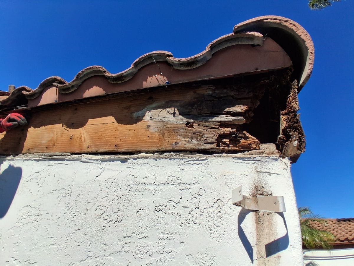 Visible roof-edge and fascia deterioration above an exterior wall on an AWC project